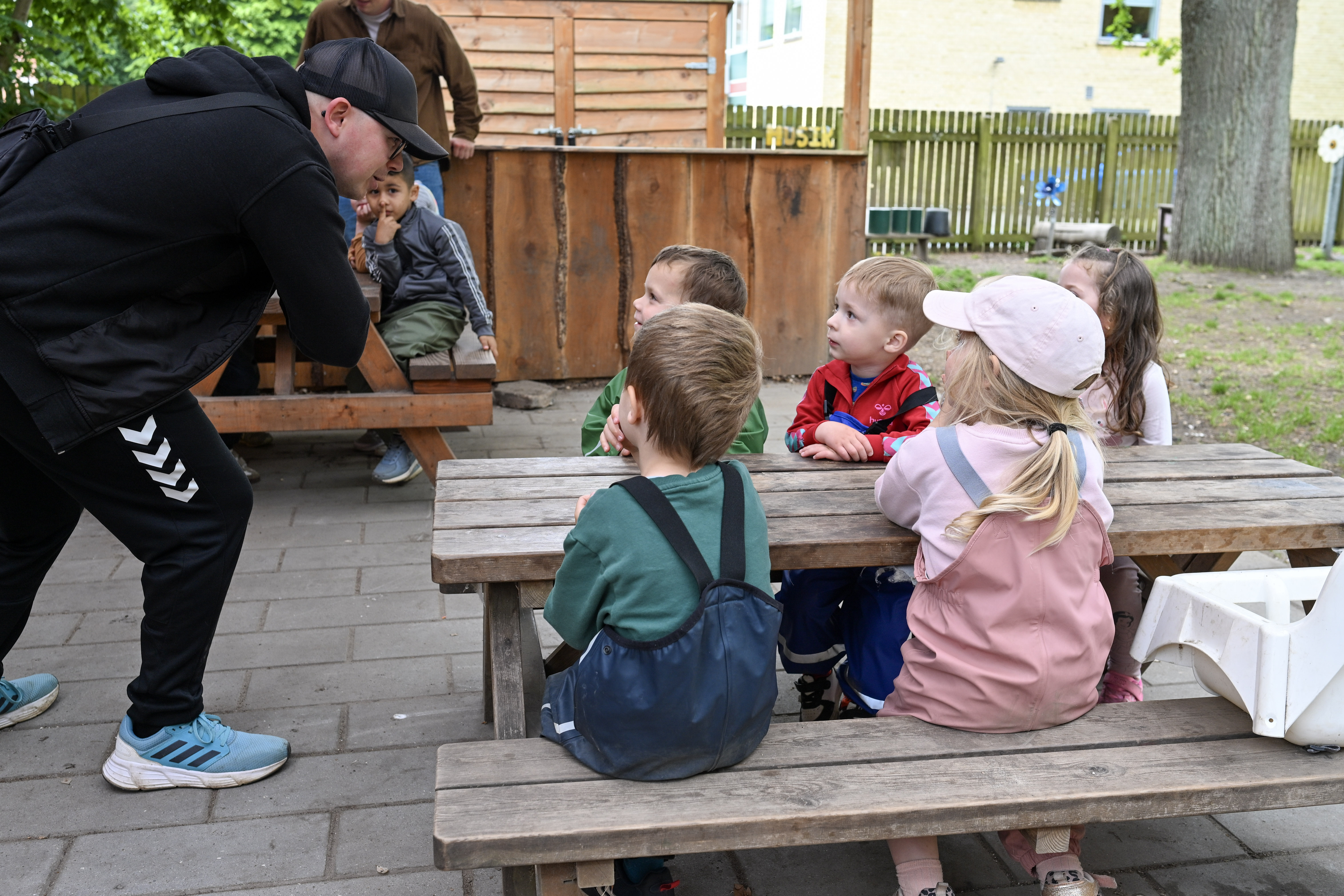 Voksen snakker med børn udenfor